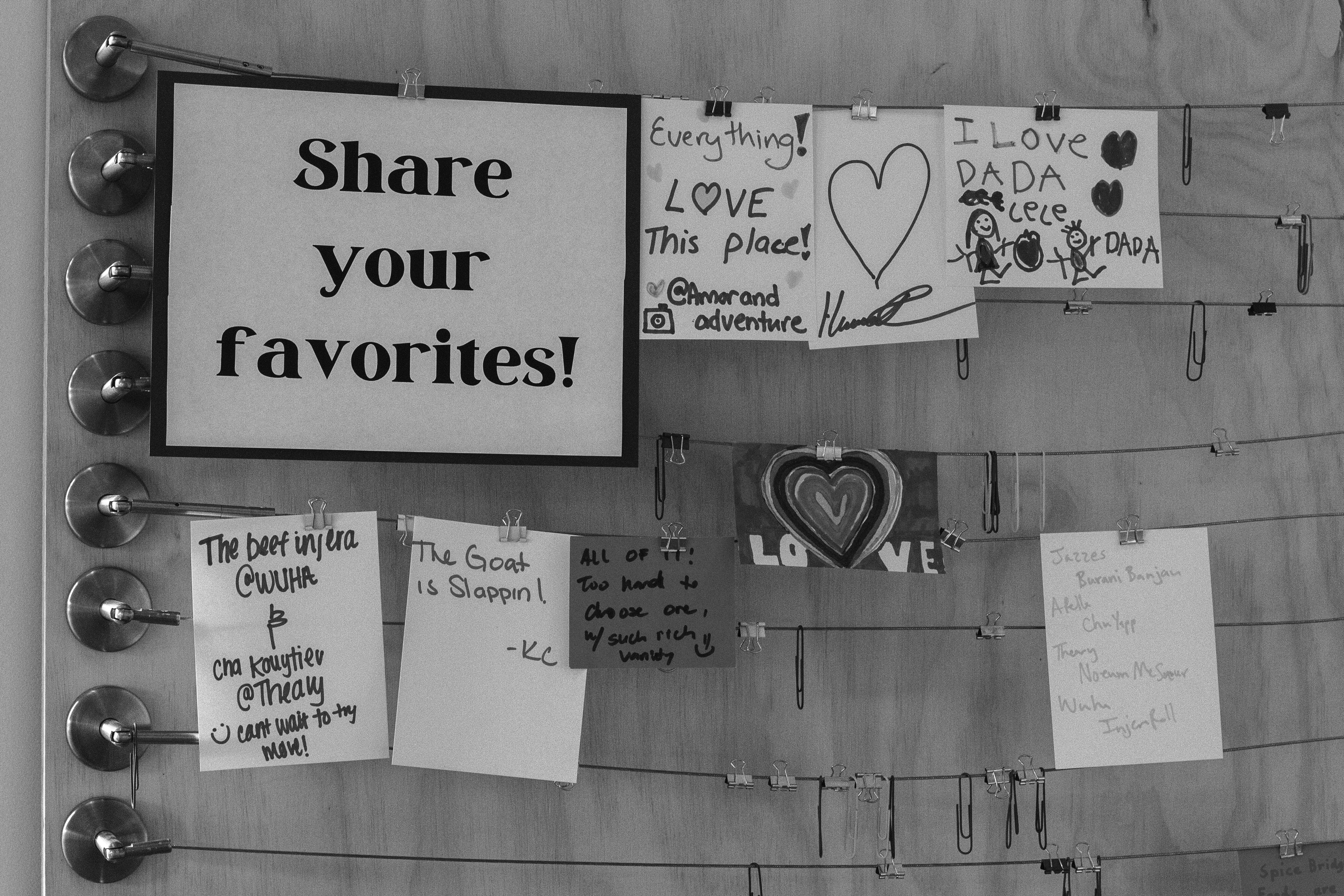 Notes of appreciation for a Cambodian business hanging on wall with a sign that reads "Share your favorites!"